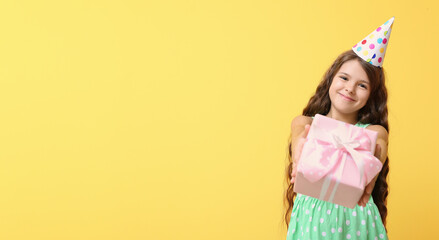 Obraz na płótnie Canvas Little girl with birthday gift on color background