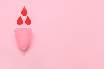 Composition with menstrual cup and blood drops on pink background