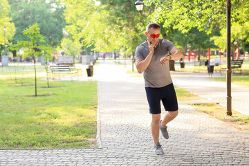 Male runner checking pulse outdoors