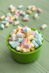 Ramekin with tasty marshmallows on color wooden background, closeup