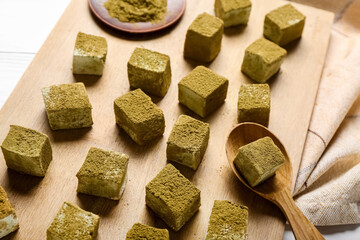 Board with tasty hojicha marshmallows on table, closeup