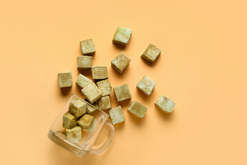 Glass cup with Tasty hojicha marshmallows on color background