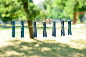 Plastic clothespins hanging on laundry line outdoors
