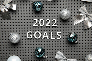 Board with text 2022 GOALS and New Year decor, top view