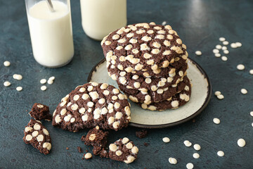 Plate with tasty homemade chocolate cookies on dark background