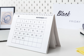 Calendar page of November 2022 on white table. Black Friday