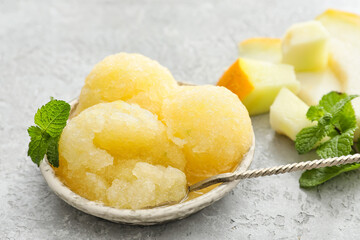 Plate with tasty melon sorbet and mint on light background