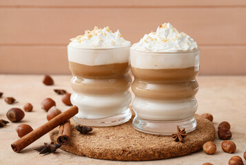 Glasses of tasty latte with nuts on table