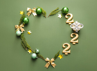 Heart made of coniferous branches, Christmas decorations and figure 2022 on color background