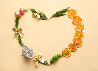 Heart made of coniferous branches, Christmas decorations and dried orange slices on color background