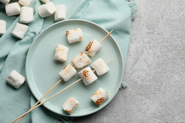 Plate with delicious grilled marshmallow on light background