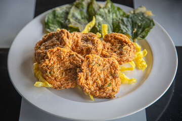 Fried fish-paste balls in white dish.