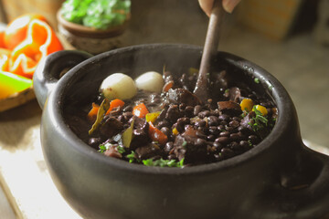 Serving feijoada, a Brazilian dish on a lunch table