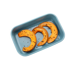 Dish with tasty baked pumpkin pieces on white background