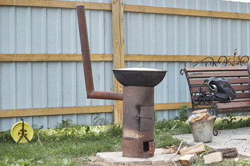 In the backyard there is a rusty oven for cooking Uzbek pilaf