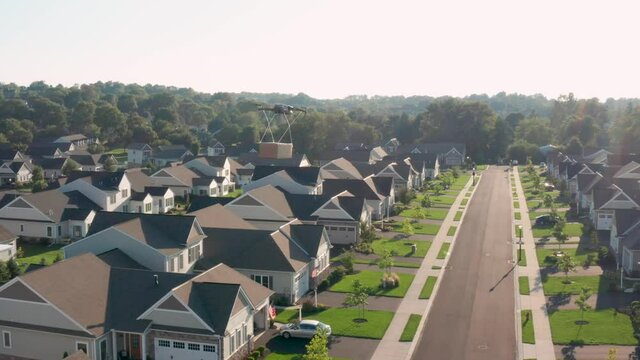 Drone delivers package to residential neighborhood. Aerial of drone flying.
