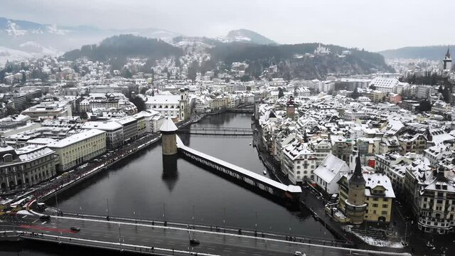Aerial flyover towards Kappelbr&uuml;cke in Lucerne, Switzerland as the city is covered in snow in winter