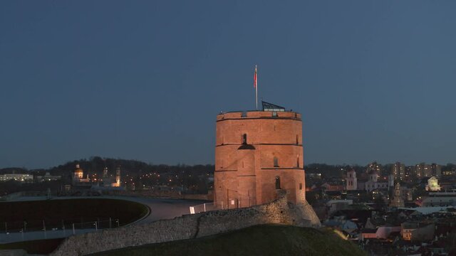 High quality drone footage of Vilnius, Capital of Lithuania in the late evening. Streets, lights, Old Town, bridge, river Neris, Gediminas Castle Tower visible.