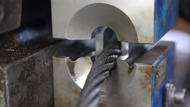 Pulling steel wire rope through talurit swaged sleeve in hydraulic press, creating loop