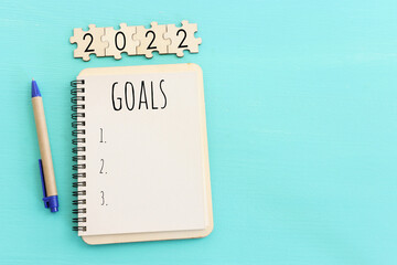 Business concept of top view 2022 goals list with notebook over wooden desk