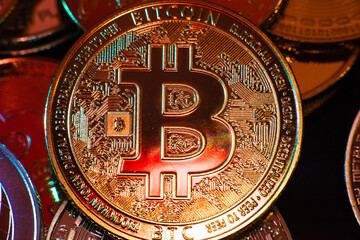 Horizontal view of cryptocurrency tokens, including Bitcoin, dogecoin, and ethererum seen from above on a black background. High quality photo