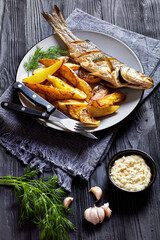 Roasted sea bass on a plate with french fries