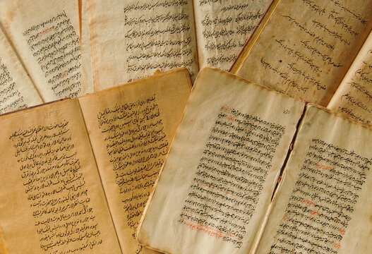 Stack of open ancient books in Arabic. Old Arabic manuscripts and texts. Top view