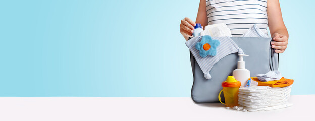 Banner. Woman packing diaper bag on blue.