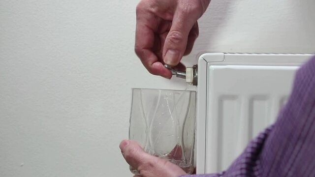 man is taking the air out of a radiator