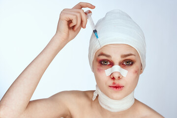 portrait of a woman bandaged face the syringe sticks out in the head isolated background