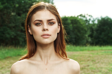 Naklejka premium portrait of a woman attractive look bare shoulders green leaves Lifestyle