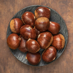 Chestnuts on on an old board with copy space. Autumn mood.  Horse chestnuts top view