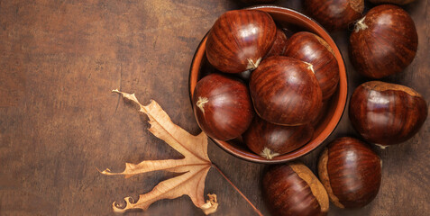 Chestnuts on on an old board with copy space. Autumn mood.  Horse chestnuts top view