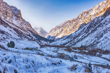 Idyllic winter landscape with hiking people in the mountains. Rocks, snow and stones in mountain...
