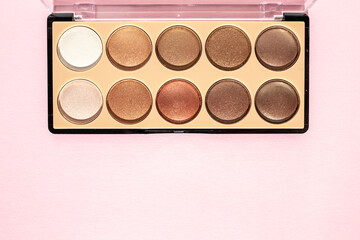 Makeup palette with beige sparkling eyeshadow on a powdery background. Flat lay, place for text.