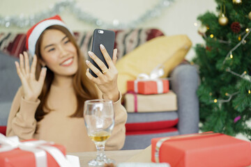 close up asian woman video call to talking and greeting with friends and family in ornamental living room at home for christmas celebration and people technology concept