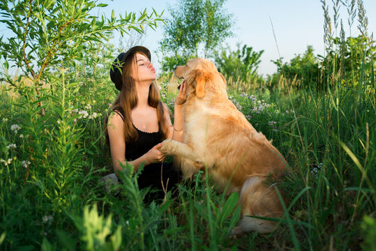 The dog is man's friend. The attitude of a person to a dog. Golden retriever - Powered by Adobe