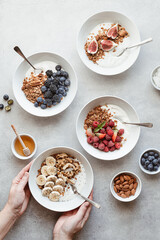 Granola with yogurt, berries, fruits and nuts on a concrete background, top view 