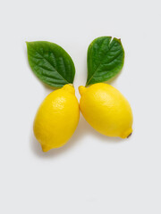 Lemons with a green leaf on a white background.