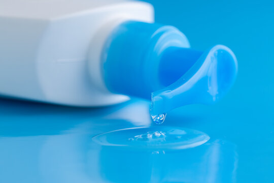 bottle of Intimate lubricant gel on blue. Intimate massage and comfortable sex consept. Cosmetic bottle.