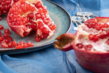 Fresh juicy ripe pomegranate on a wooden background, close-up. Pomegranate fruit, cut in half