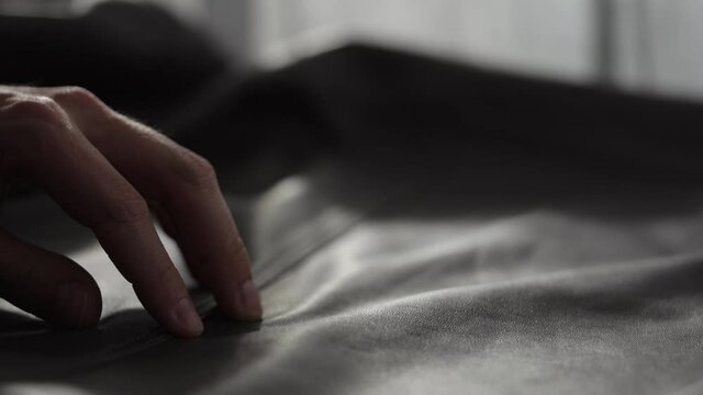 Slow motion shot man touching fine leather closeup