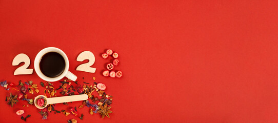 Numbers 2022 of fruit and berry dry tea leafs on red background,flat lay.Copy space.Happy New year concept.Top view