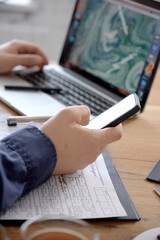 Hand with smart phone screen against wooden table