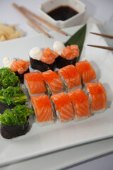 Salmon sushi set. Sushi roll Philadelphia with red fish, salmon, red caviar. Roll with soft avocado and cream cheese under a layer of massago caviar. Classic sushi. Food background.