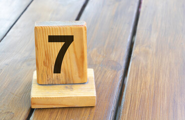 Wooden priority number 7 on a plank tab