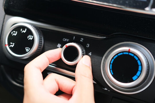 Person finger turn off the car air conditioner knob