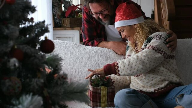 Happy woman opening Christmas gift of husband