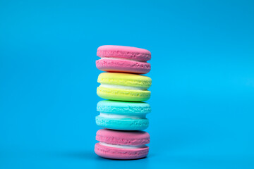 Pile of fresh baked colorful French macaroons on blue background , copy space banner. dessert,cookie,cake concept