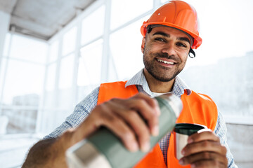 Portrait of a man worker in workwear on a break drink coffee and have rest
